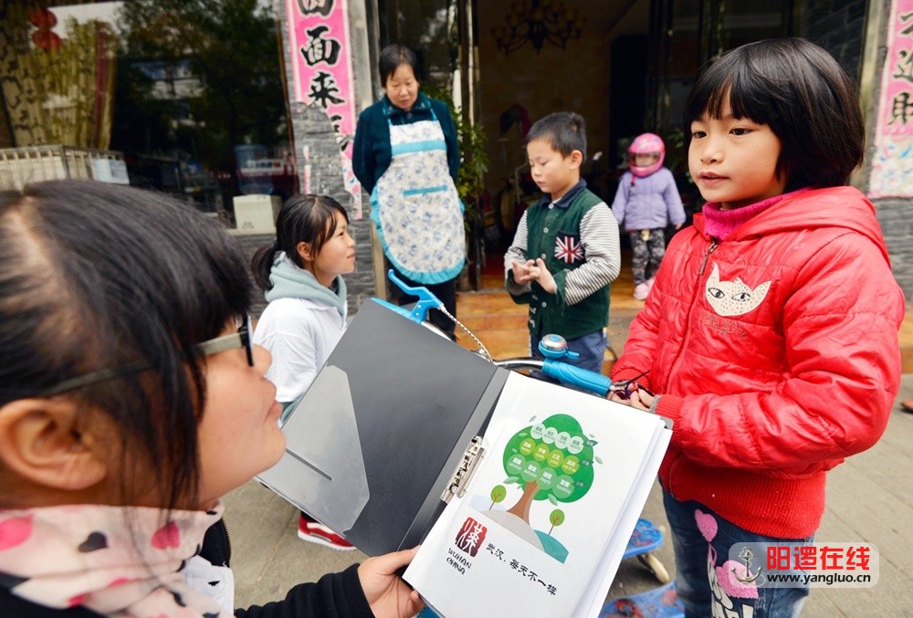 网友们在邾城街头调查问卷，小学生在背诵社会主义核心价值观。吴毅摄影